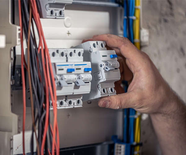 Technicien électricien installant un tableau électrique neuf